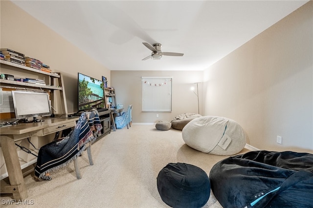 carpeted office space featuring baseboards and ceiling fan