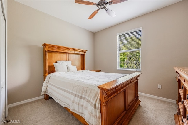 bedroom featuring ceiling fan, light carpet, and baseboards