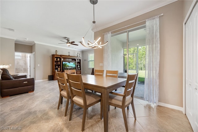 dining area with baseboards, light tile patterned flooring, ornamental molding, and ceiling fan with notable chandelier