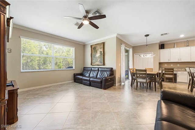 living area featuring ceiling fan, ornamental molding, and baseboards