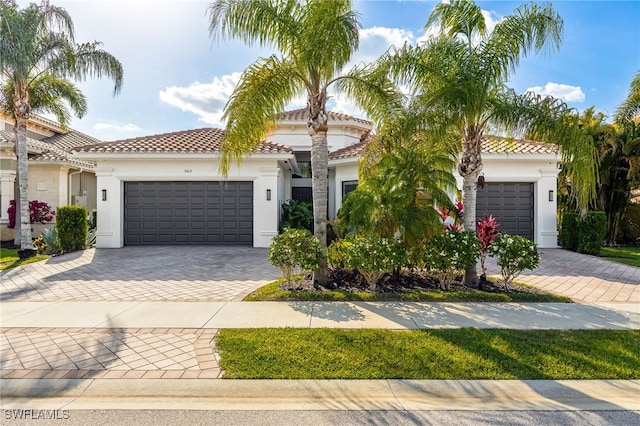 3412 Atlantic Cir, Naples, FL 34119 - mediterranean / spanish-style house featuring stucco siding, an attached garage, and decorative driveway
