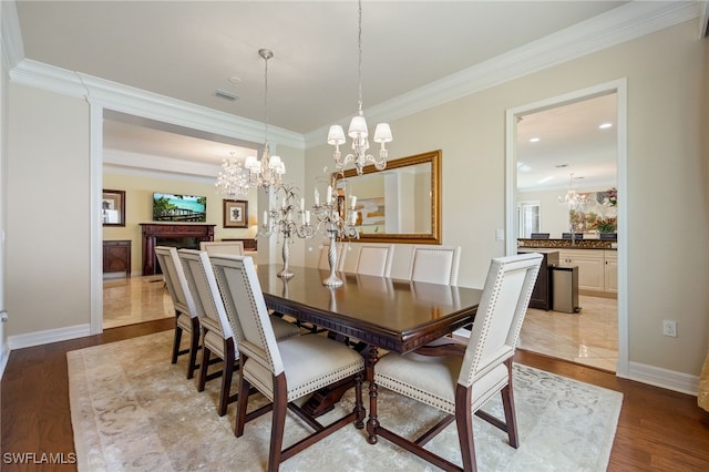 3412 Atlantic Cir, Naples, FL 34119 - dining space with crown molding, an inviting chandelier, wood finished floors, and visible vents