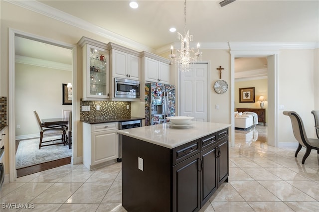 3412 Atlantic Cir, Naples, FL 34119 - kitchen featuring tasteful backsplash, a notable chandelier, glass insert cabinets, ornamental molding, and stainless steel appliances