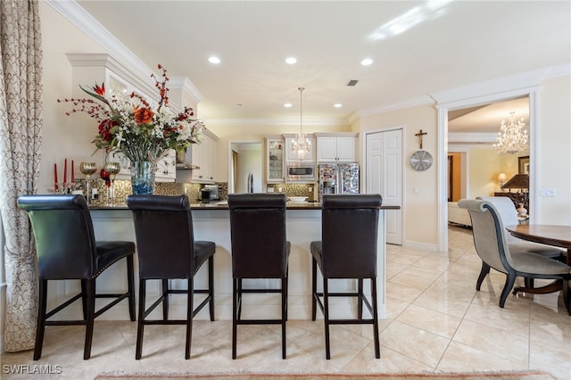 3412 Atlantic Cir, Naples, FL 34119 - kitchen featuring a breakfast bar area, dark countertops, appliances with stainless steel finishes, a peninsula, and an inviting chandelier