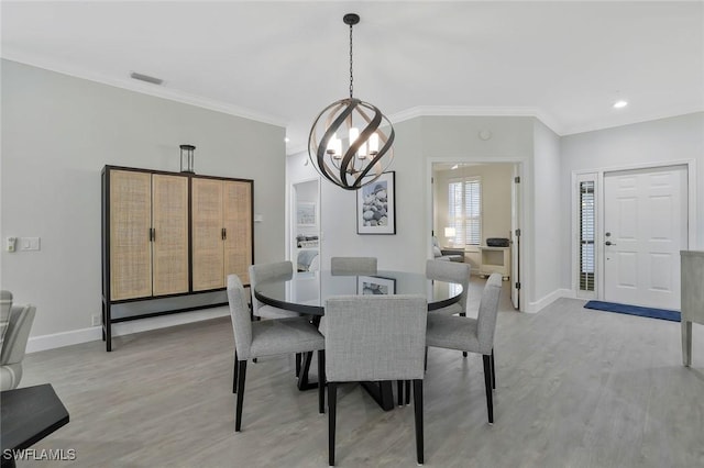 dining space featuring an inviting chandelier, ornamental molding, baseboards, and light wood-type flooring