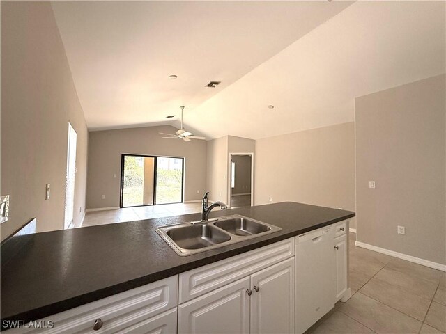 kitchen featuring dark countertops, a sink, lofted ceiling, and dishwasher