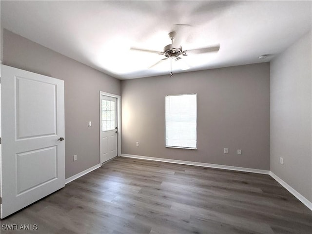 unfurnished room featuring baseboards, ceiling fan, and wood finished floors