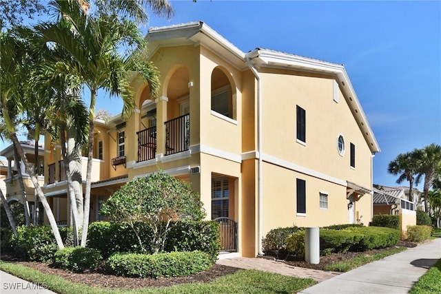 view of home's exterior featuring a balcony and stucco siding