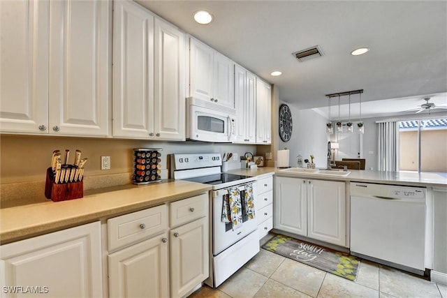 kitchen featuring a sink, white appliances, light countertops, light tile patterned floors, and visible vents