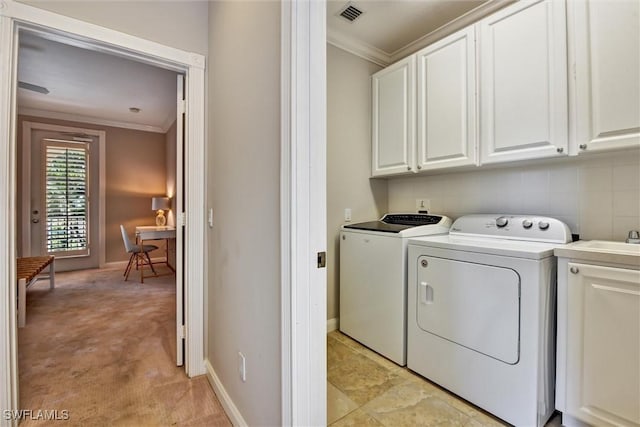 laundry room featuring visible vents, ornamental molding, washing machine and dryer, baseboards, and cabinet space