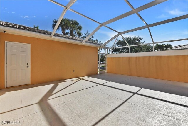 view of patio featuring glass enclosure