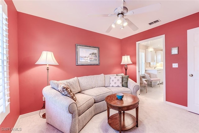 3775 Fieldstone Blvd Unit 104, Naples, FL 34109 - living room featuring visible vents, baseboards, ceiling fan, and light colored carpet