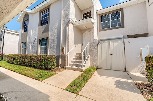 3775 Fieldstone Blvd Unit 104, Naples, FL 34109 - view of front of home with a gate, stucco siding, and a fenced front yard
