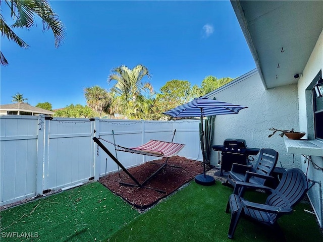 view of yard with a fenced backyard and a gate