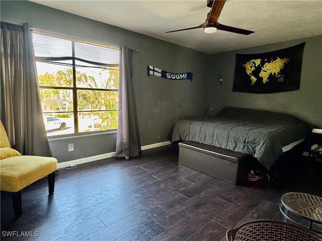 bedroom featuring dark wood-type flooring, a ceiling fan, and baseboards