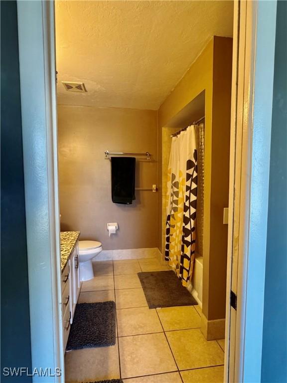 full bath with a textured ceiling, visible vents, tile patterned flooring, vanity, and baseboards