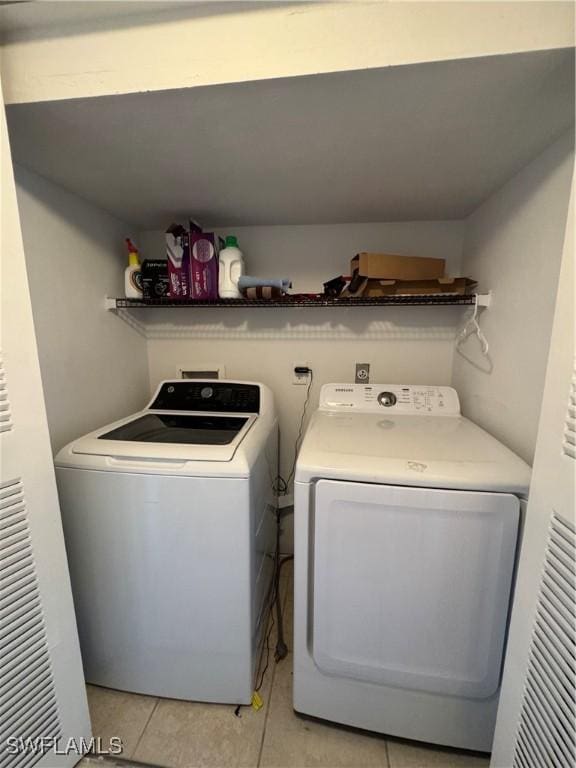 laundry room with laundry area, light tile patterned floors, and washing machine and clothes dryer