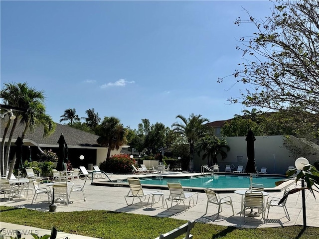 community pool featuring fence and a patio