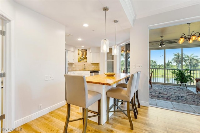 dining room with baseboards, a healthy amount of sunlight, and light wood finished floors