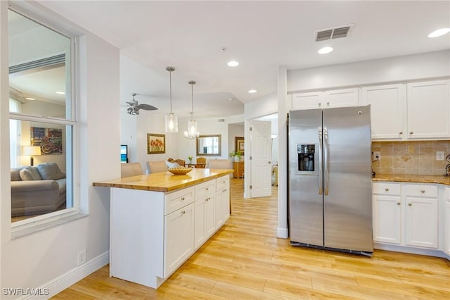 kitchen with stainless steel fridge with ice dispenser, light wood-style flooring, white cabinetry, and visible vents