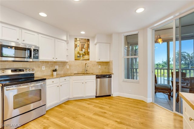 kitchen featuring light wood-style floors, a sink, tasteful backsplash, and stainless steel appliances
