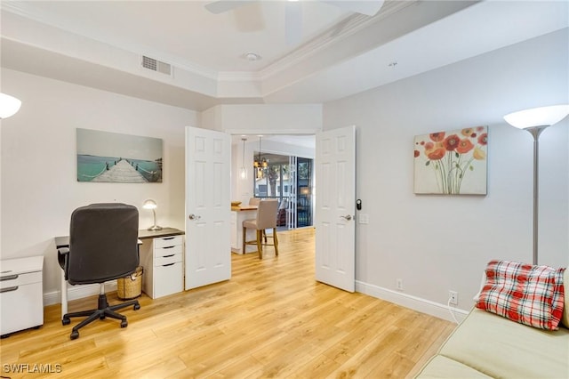 home office featuring light wood-style floors, crown molding, ceiling fan, and visible vents