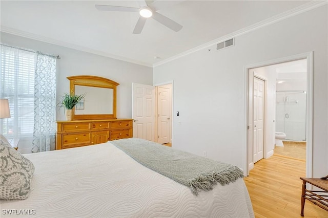 bedroom with visible vents, ornamental molding, light wood-style floors, ceiling fan, and ensuite bath