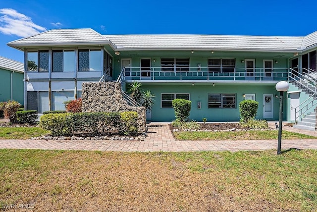 3225 E Riverside Dr Unit 26B, Fort Myers, FL 33916 - view of front of home featuring stairway, stucco siding, and a front yard
