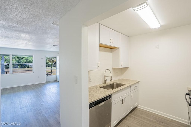 3225 E Riverside Dr Unit 26B, Fort Myers, FL 33916 - kitchen featuring a sink, dishwasher, light wood finished floors, baseboards, and white cabinetry