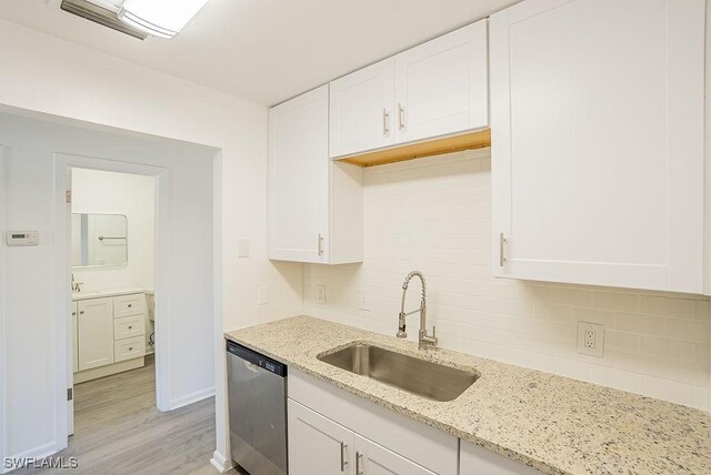 3225 E Riverside Dr Unit 26B, Fort Myers, FL 33916 - kitchen featuring a sink, stainless steel dishwasher, backsplash, and white cabinetry