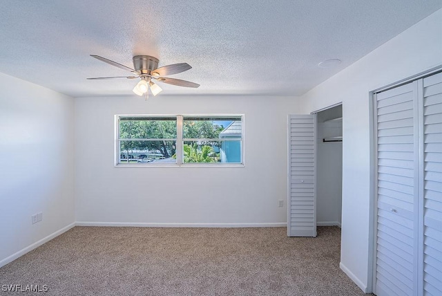 3225 E Riverside Dr Unit 26B, Fort Myers, FL 33916 - unfurnished bedroom with carpet, a textured ceiling, a ceiling fan, baseboards, and two closets