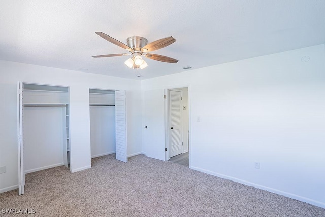 3225 E Riverside Dr Unit 26B, Fort Myers, FL 33916 - unfurnished bedroom featuring multiple closets, carpet floors, baseboards, and a ceiling fan