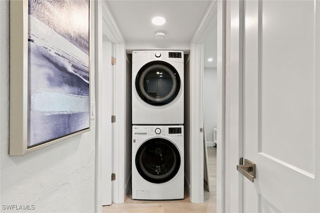 261 S Collier Blvd Unit 304, Marco Island, FL 34145 - clothes washing area featuring wood finished floors and stacked washer / dryer
