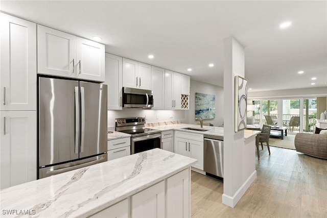 261 S Collier Blvd Unit 304, Marco Island, FL 34145 - kitchen featuring a sink, open floor plan, stainless steel appliances, recessed lighting, and light wood-style flooring