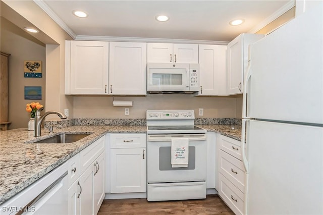 kitchen with white appliances, white cabinets, a sink, and dark wood-type flooring
