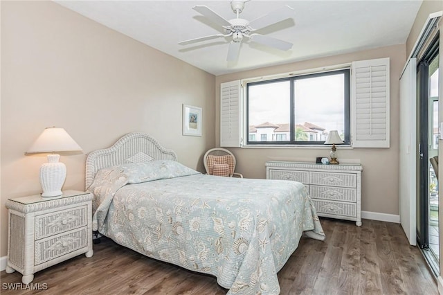 bedroom with baseboards, multiple windows, and wood finished floors