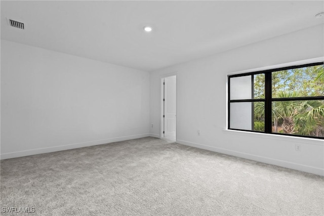 empty room featuring carpet flooring, baseboards, and recessed lighting