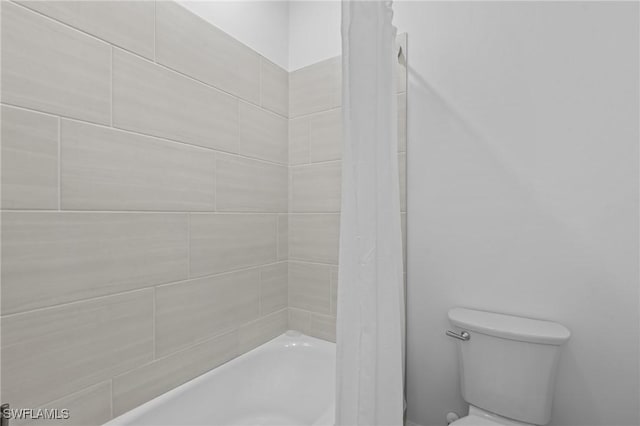 bathroom featuring toilet and shower / bath combo with shower curtain