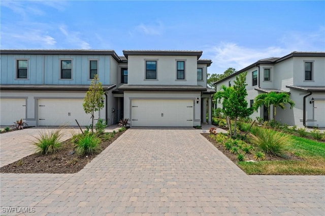 view of front of property with an attached garage, decorative driveway, and stucco siding