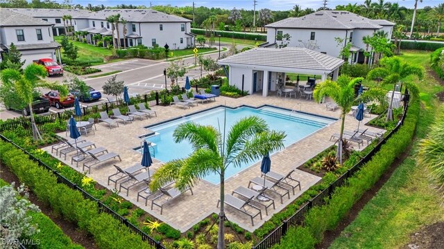 community pool featuring fence and a residential view