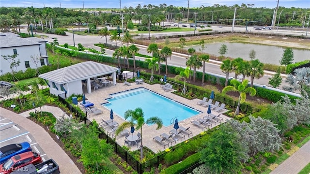 community pool with a patio area and a water view