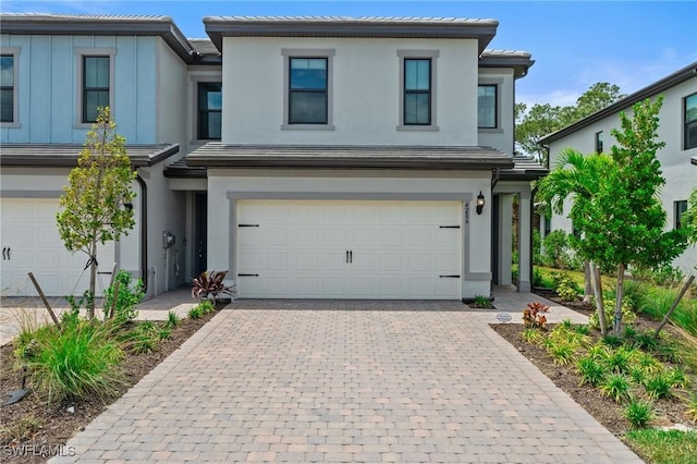 view of front of property featuring decorative driveway, a garage, stucco siding, and a tile roof