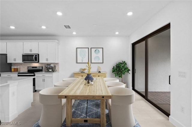 kitchen with stainless steel appliances, white cabinetry, backsplash, recessed lighting, and light countertops