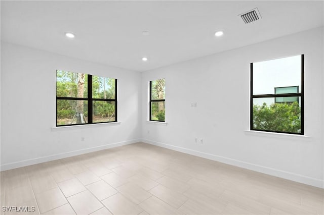 spare room with baseboards and recessed lighting