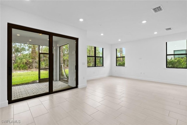 empty room featuring baseboards and recessed lighting