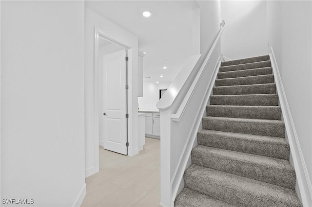stairs featuring recessed lighting, wood finished floors, and baseboards