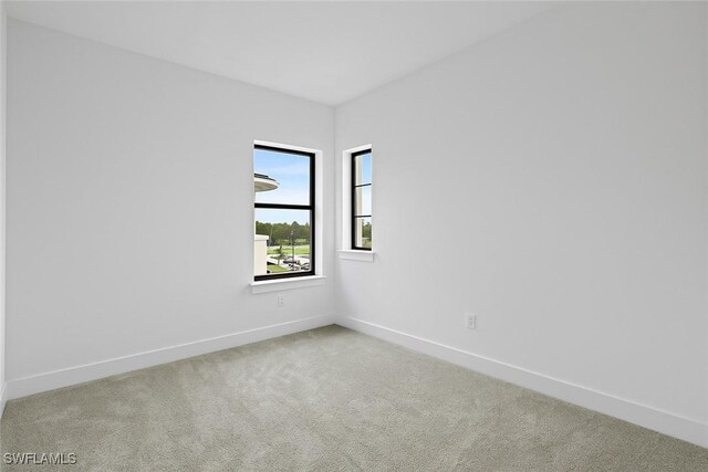 carpeted spare room with baseboards