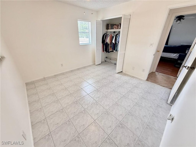 314 Vermont Way, Lehigh Acres, FL 33936 - unfurnished bedroom featuring light tile patterned floors, a closet, and a textured ceiling