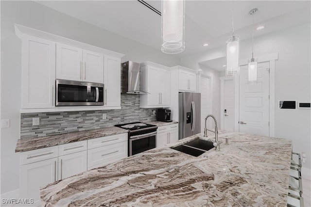 kitchen with wall chimney range hood, a sink, stainless steel appliances, white cabinetry, and tasteful backsplash