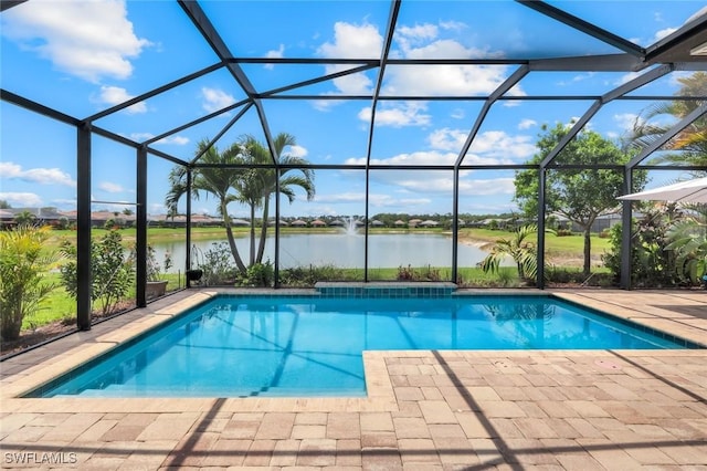 outdoor pool with a water view, a patio, and glass enclosure